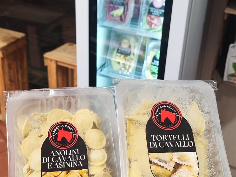 Vaschette Taberna Equina di anolini di cavallo e asinina e tortelli, frigorifero con altre confezioni sullo sfondo