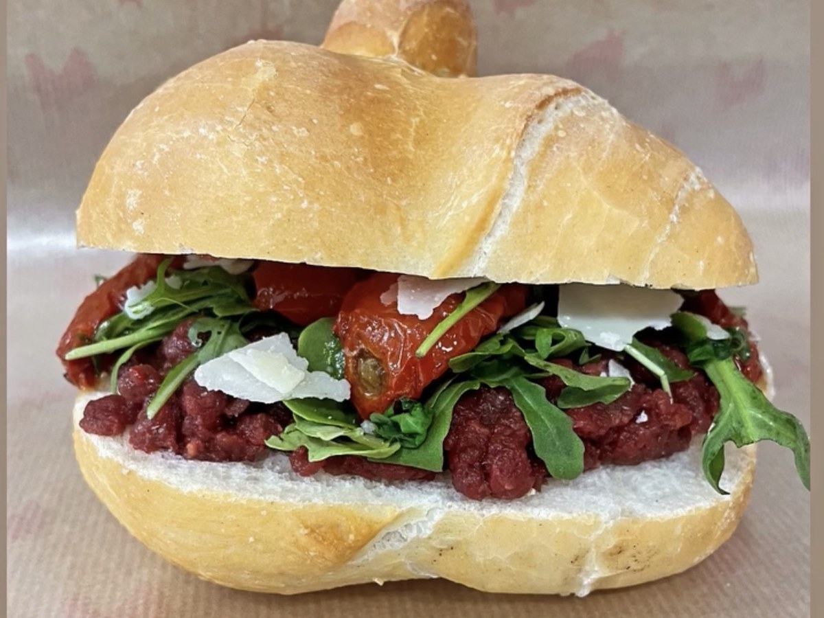 Panino Taberna Equina con pesto di cavallo crudo, rucola, scaglie di grana e pomodorini confit in una rosetta croccante